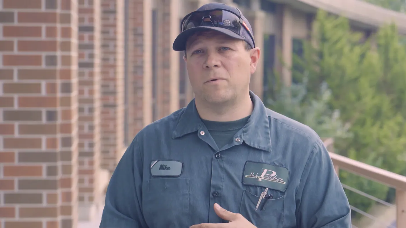 Mike Dourlain, journeyman at HJ Pertzborn Plumbing and Fire Protection, outside a brick building